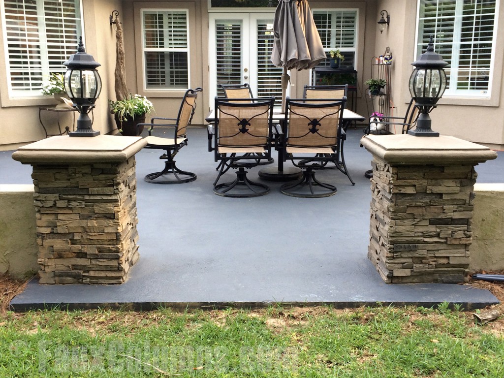 Dry stack columns with lamps attached adorn a patio entrance.