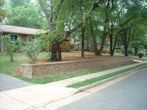 Stacked stone retaining wall made with faux panels