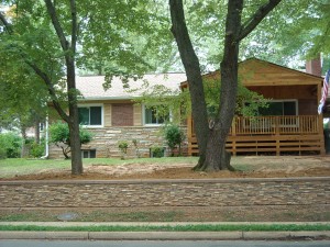The addition of faux stacked stone to this retaining wall can be achieved with little more than some wood cutting tools and construction adhesive.