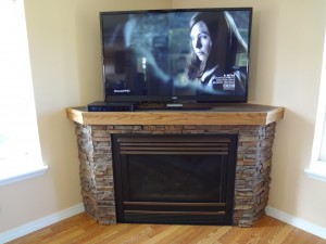 Corner fireplace updated with a stone look finish.