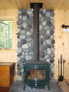 Wood stove wall shield created with River Rock style polyurethane panels.