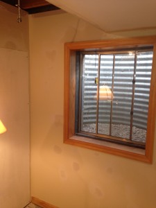 Bare, dull basement walls prior to renovating the room.