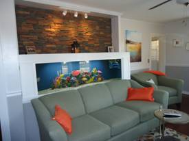 Living room wall alcove remodeled with new lighting, fish tank and stacked stone paneling.