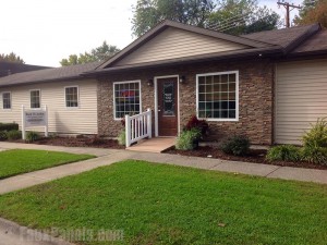 Storefront design of a chiropractor's clinic with imitation stone panels.