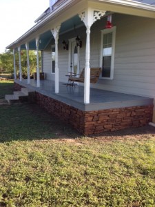 Side view of a home's front porch remodeling with ledgestone skirting