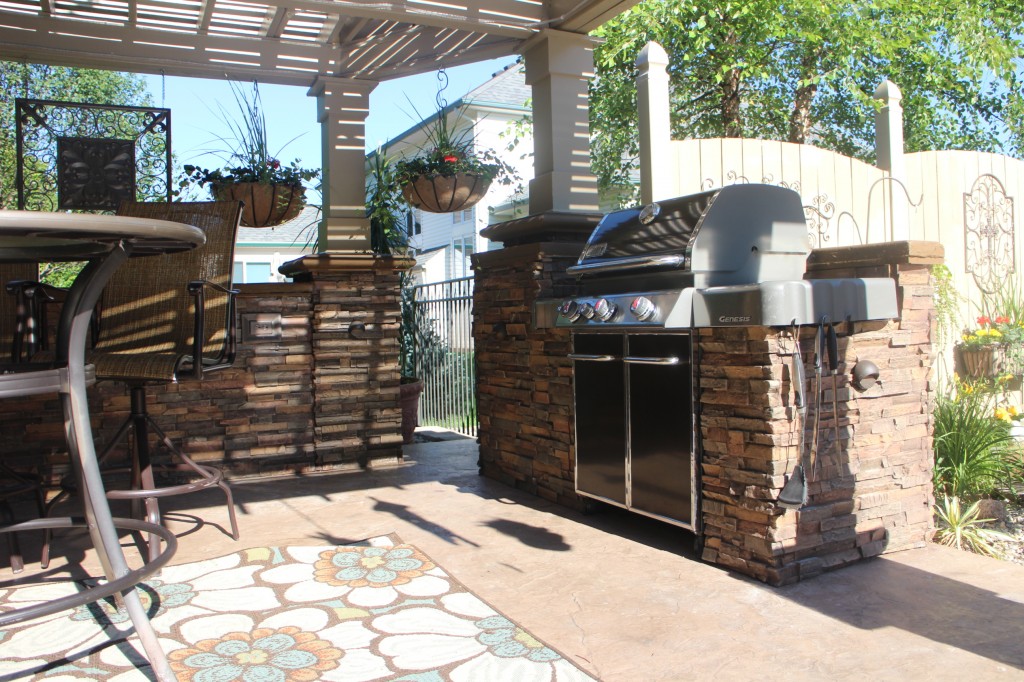 Stacked stone veneer panels enhance the grill station in this pergola.