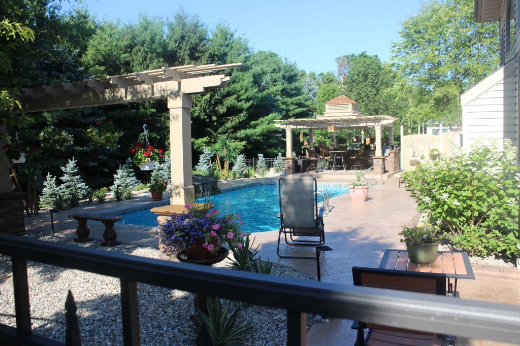 Building a pergola with fake stacked stone panels is a great way to add elegance to your poolside.