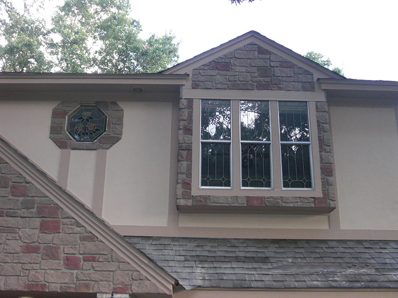 Gable windows outlined in cobblestone veneer panels
