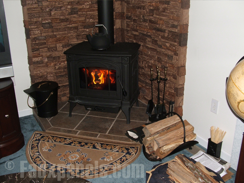 A corner wood burning stove accented with faux stacked stone panels in Sierra Brown.