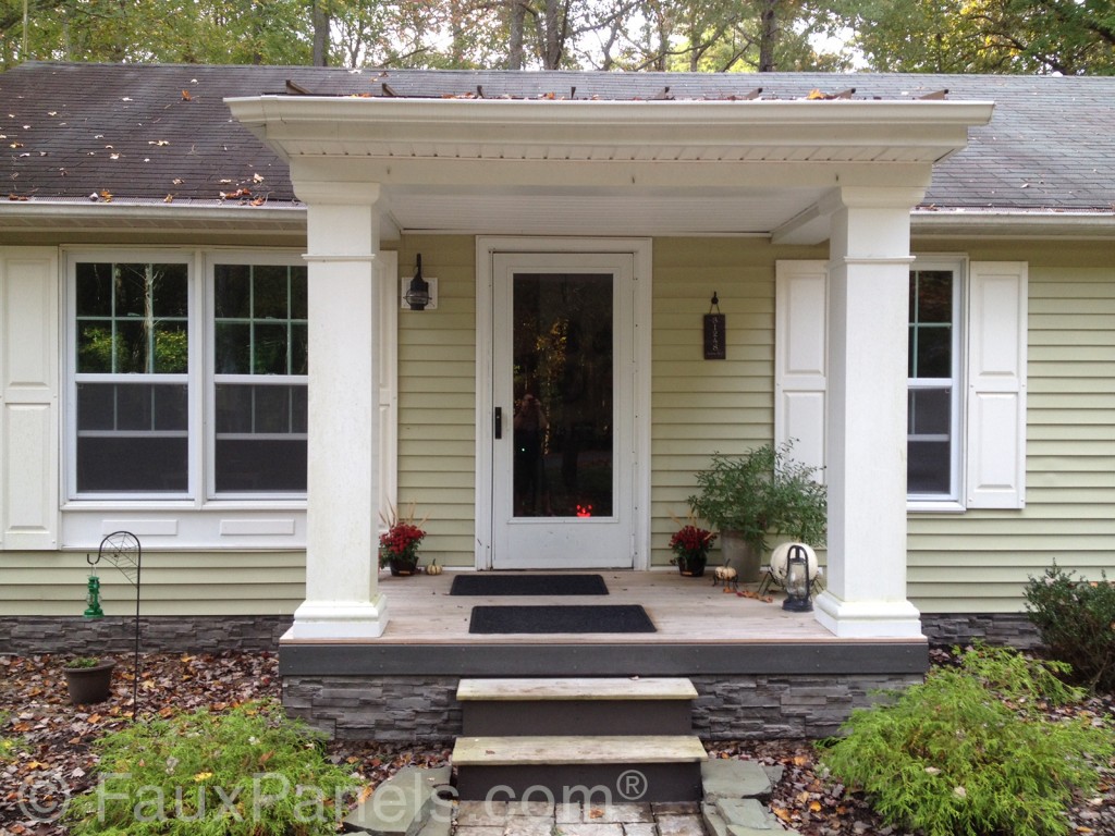 A home's front porch is accented with faux stone siding installed on the foundation.