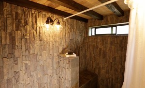 Water resistant stacked stone panels installed in a Tiny House shower area.