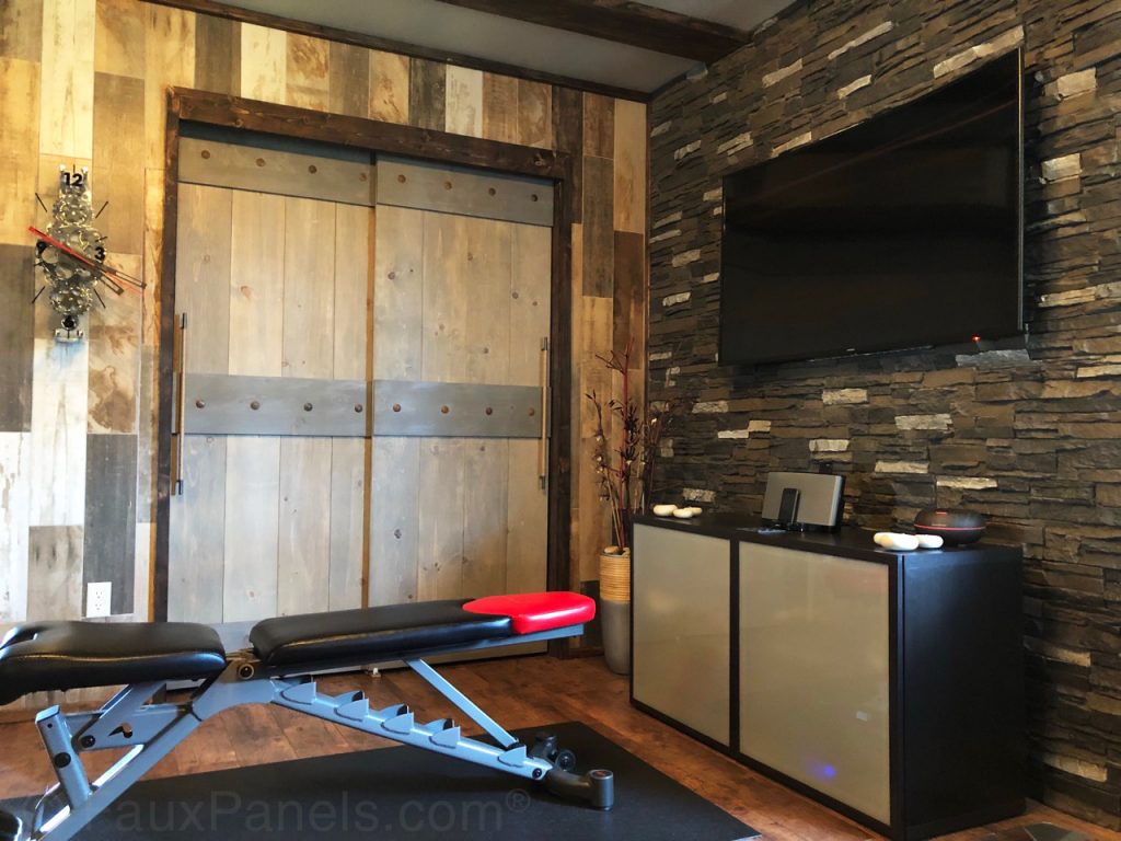 Home gym with accent wall created with Norwich Stacked Stone panels in Iced Coffee color.