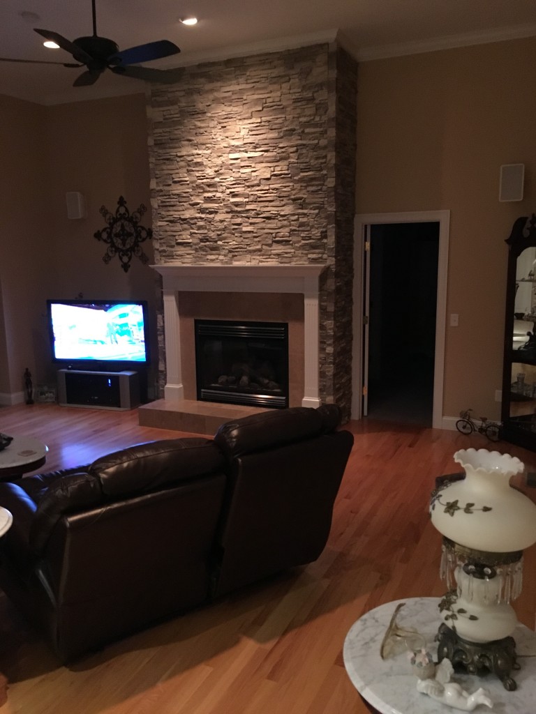 Living room transformed with a remodeled fireplace and recessed lighting to set the mood.