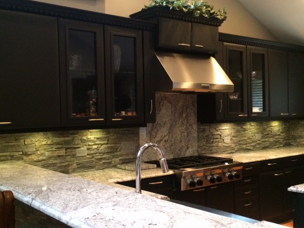 Kitchen backsplash created with custom cut polyurethane stone panels.
