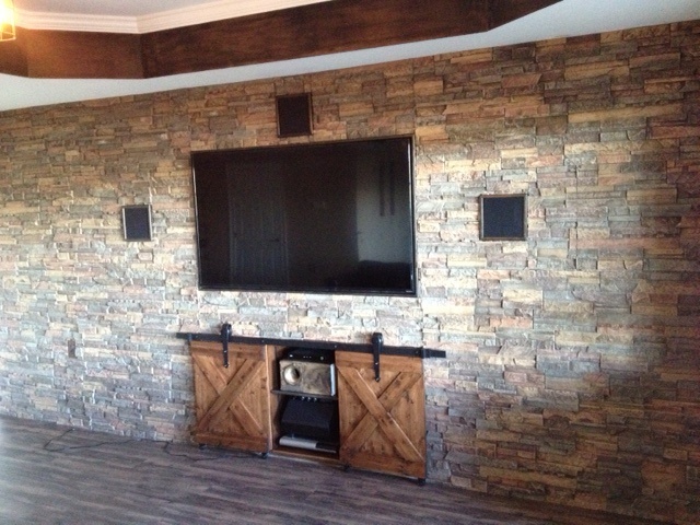 Basement wall panels with holes cut to accommodate a flat screen TV, speakers and storage cabinet