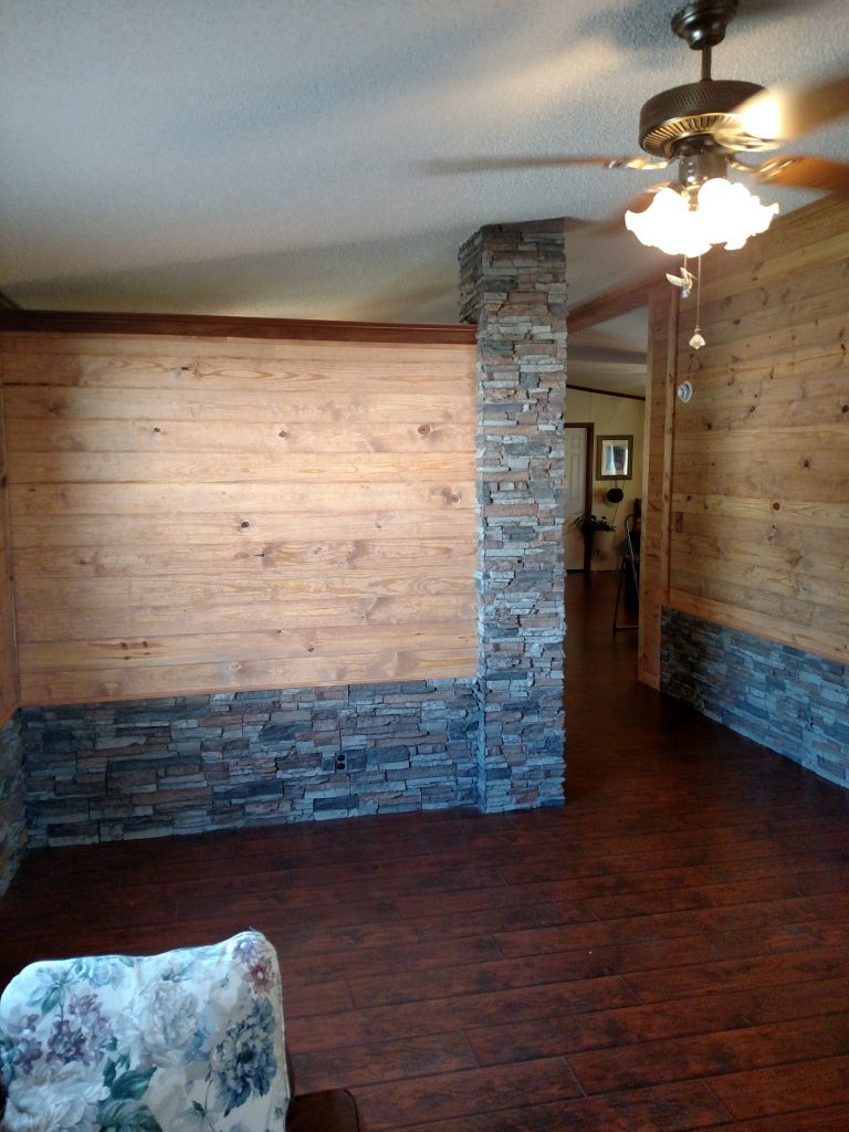 A home's original wainscoting and load bearing columns covered in faux stacked stone.