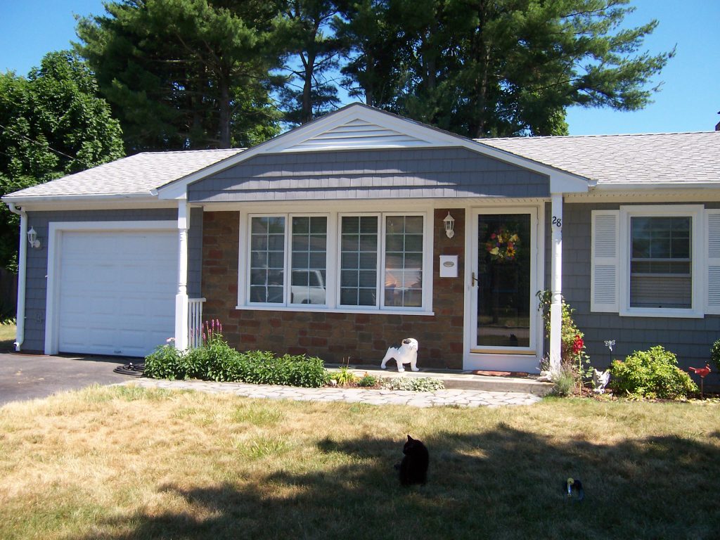 Ranch style home's porch with cobblestone style panels added to the front facing wall.