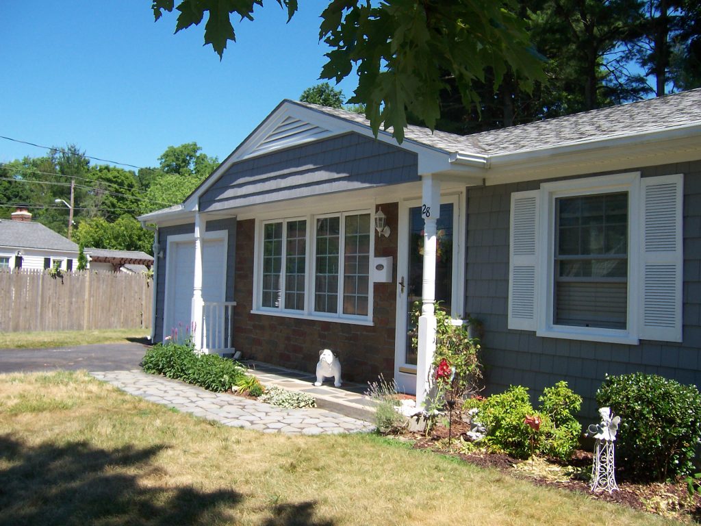 A ranch home's front porch redesigned with a faux cobblestone accent wall.