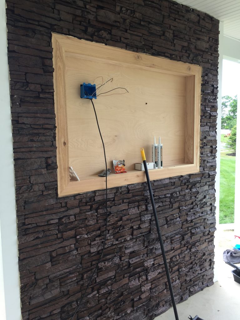Building the patio's accent wall around the recessed space for the TV.