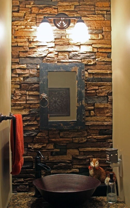 Powder room accent wall made from faux stacked stone doubling as the sink backsplash.