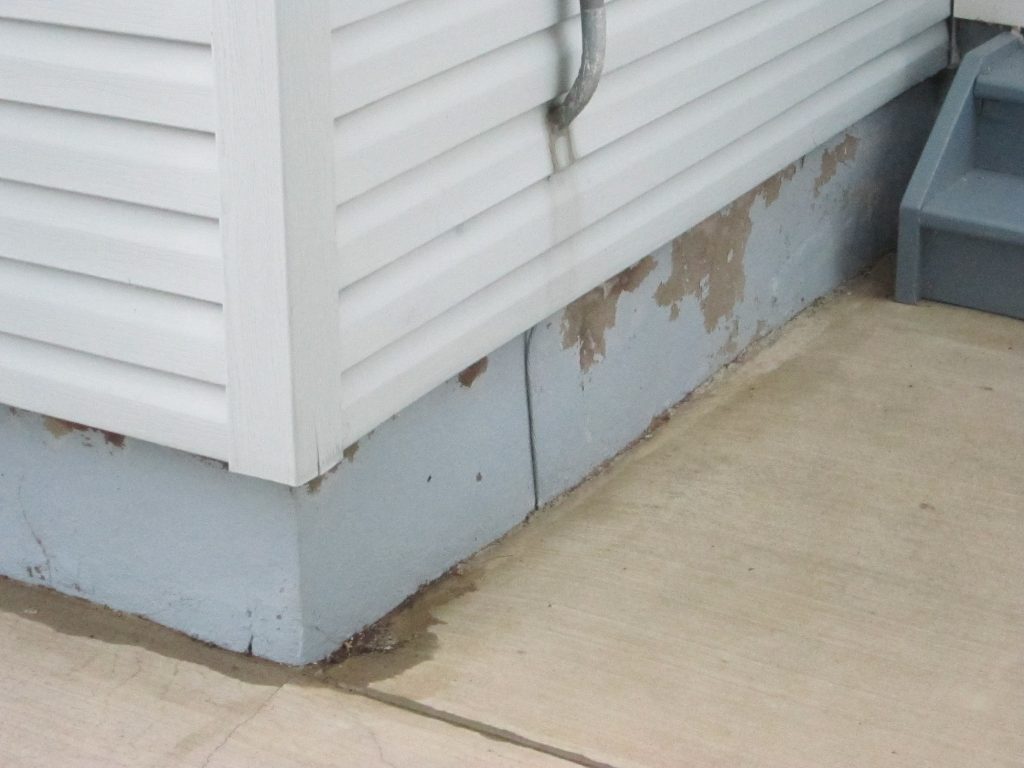 BEFORE: The ugly oily spill made paint and adhesive useless on this home's foundation.