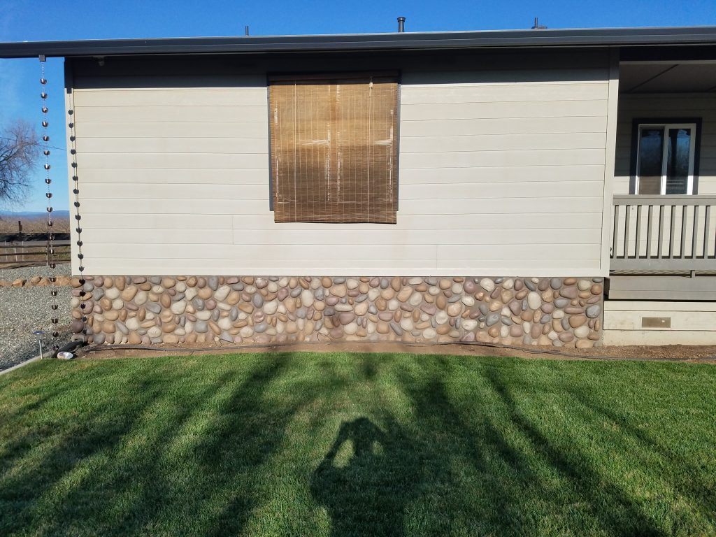 Home foundation covered in River Rock panel siding.