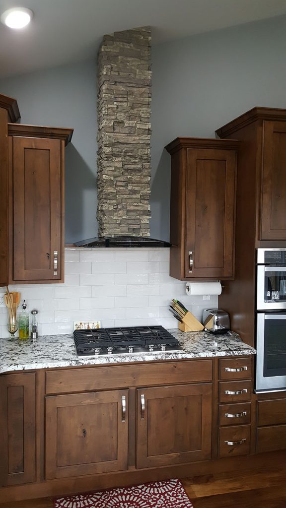 DIY range hood custom made with a stacked stone style column that assembles easily from 4 pieces.