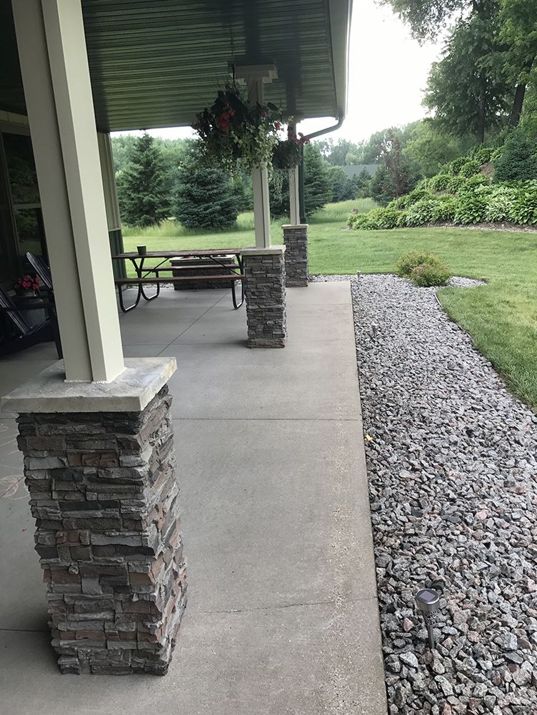 Side view of porch with stacked stone column wraps added to the base of each support post.