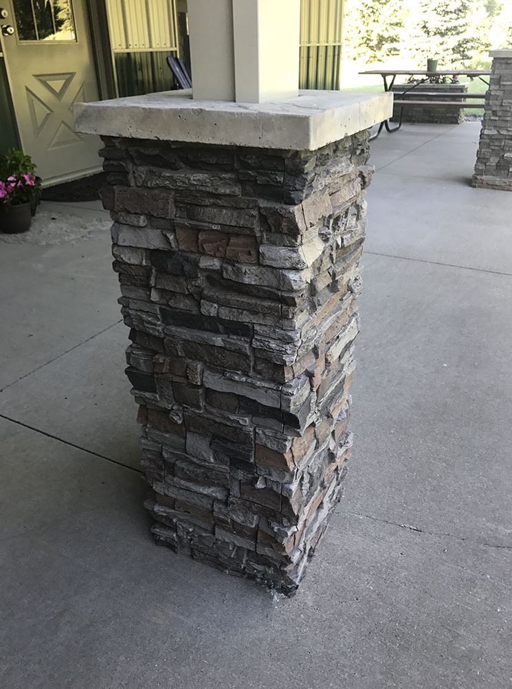 Close up view of a porch's supporting post wrapped in faux stacked stone with column cap.