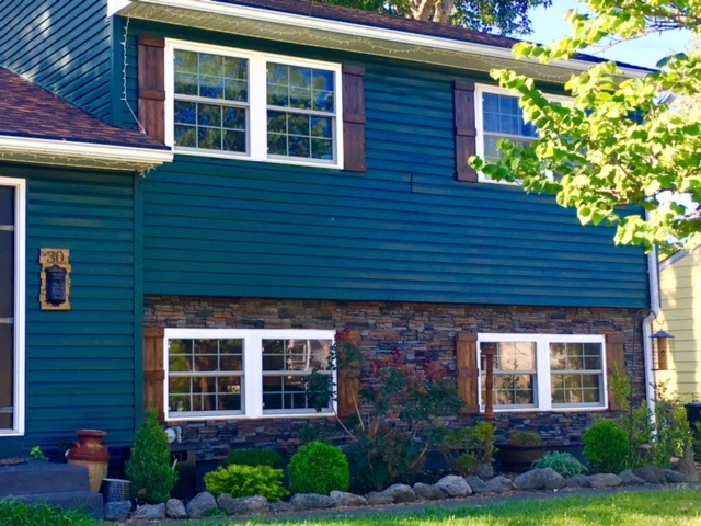 Ground floor section of home exterior accented with new stone style siding.
