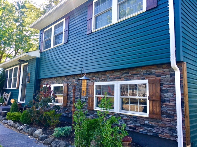 Stacked stone style siding put up on the ground floor section of a home's exterior.