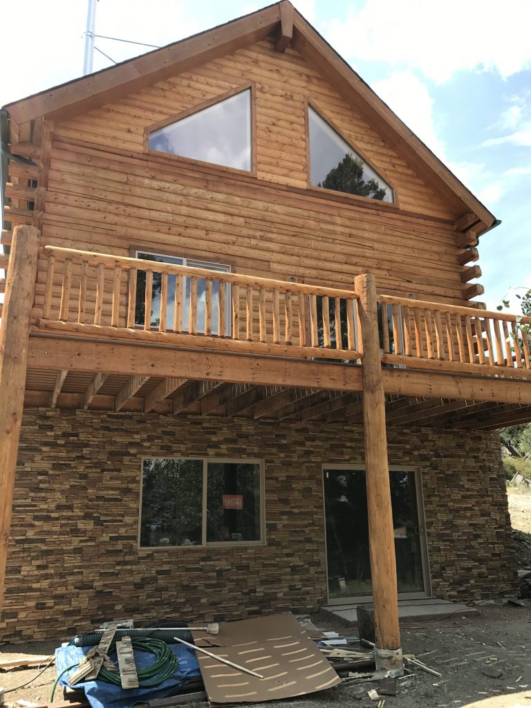 New log cabin's foundation covered with Norwich Stacked Stone panels