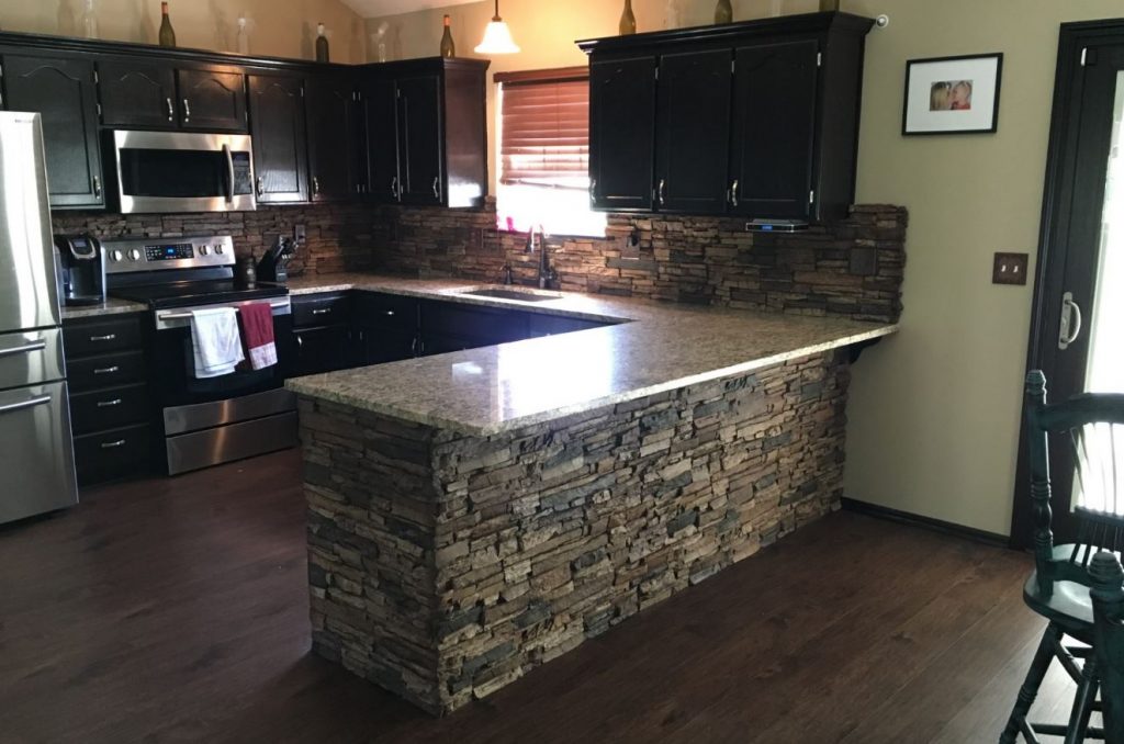 Kitchen island and backsplash covered in Norwich Stacked Stone panels in Sierra Brown.