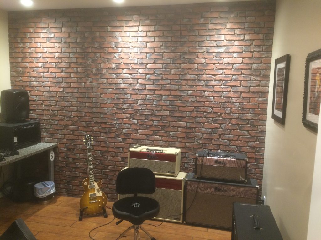 DIY music studio remodeled with a faux brick accent wall.
