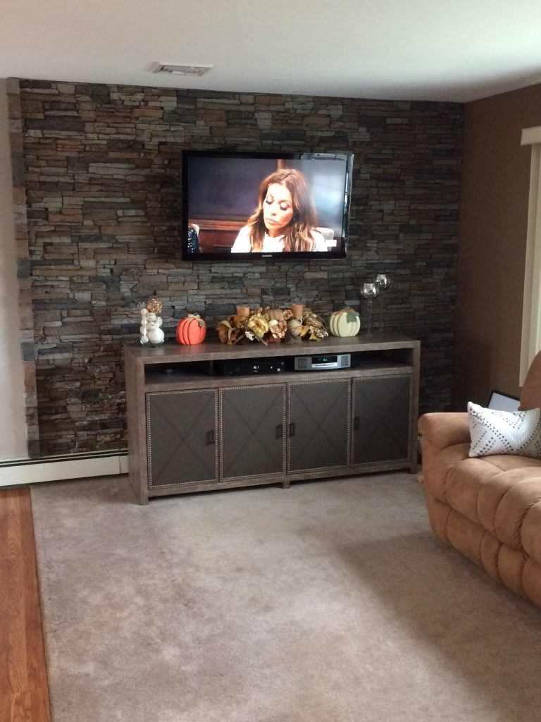 Living room accent wall made with Norwich Stacked Stone panels in Motley Gray.