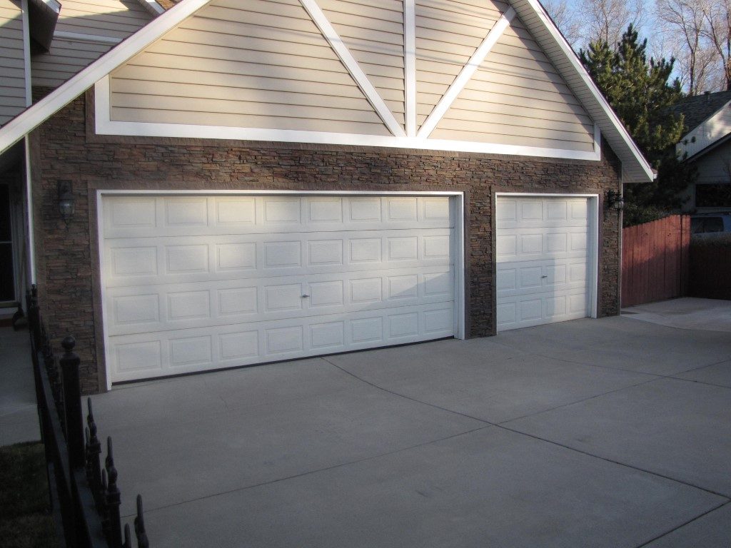 Garage exterior remodel using Regency Stacked Stone panels in Earth color and matching door trim.