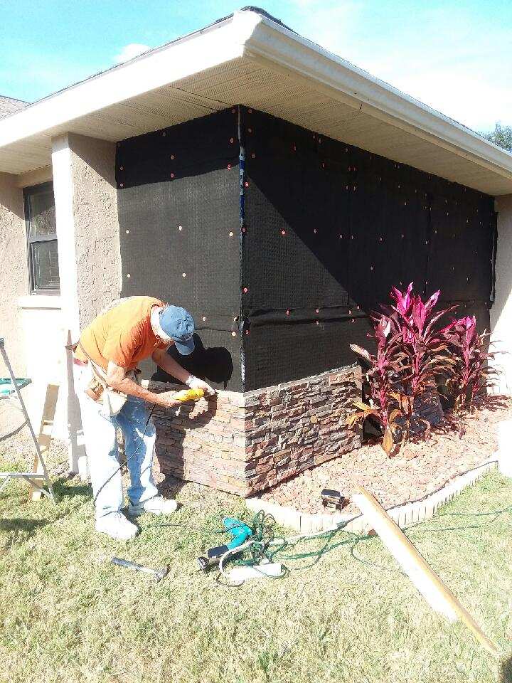 Installing siding on a home with drainage mats.