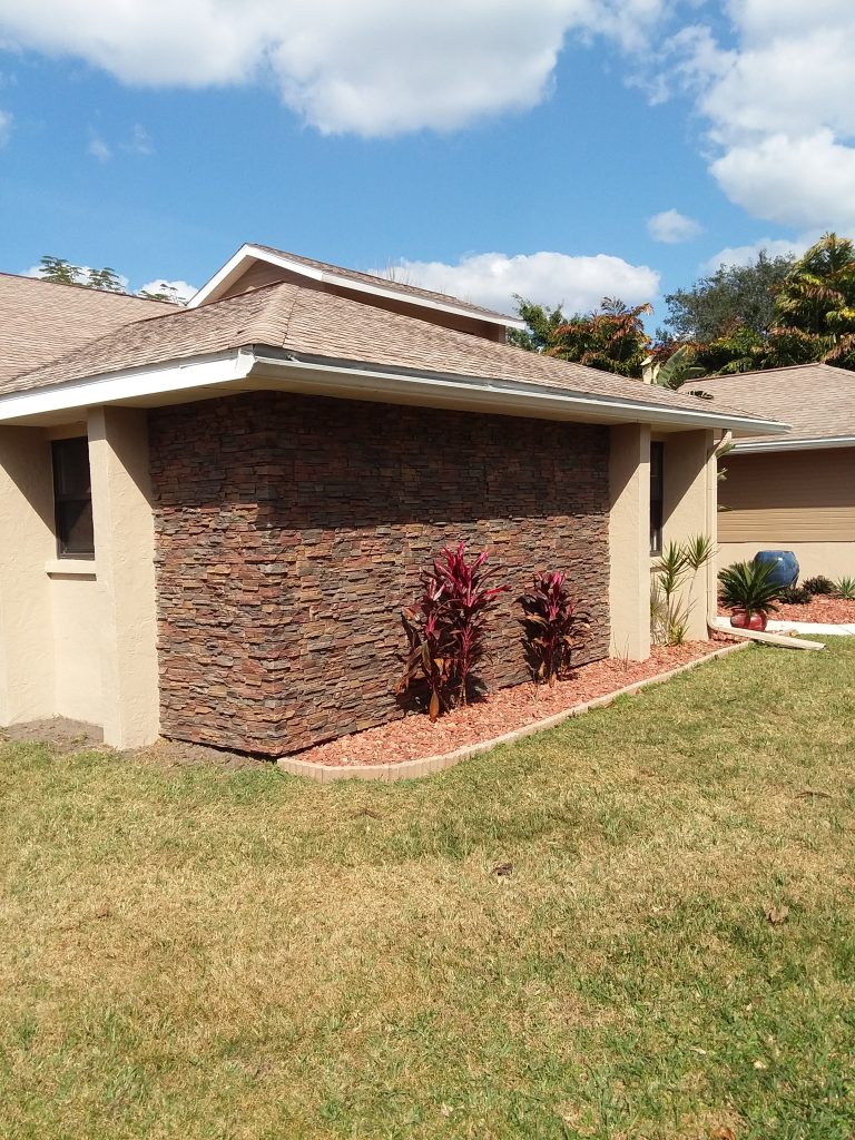 Exterior accent siding with a subtle stacked stone texture in rich earth tones.