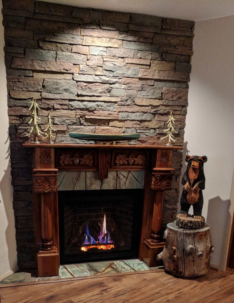 Corner fireplace surround created with Norwich Stone Wall panels in Earth color.