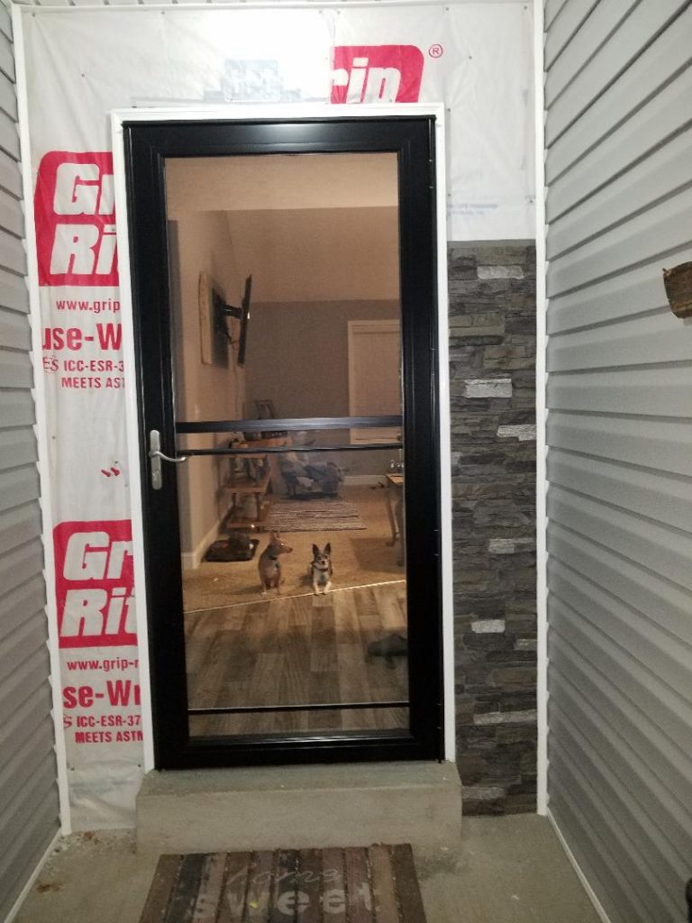 In progress image of the doorway with faux stone panels beginning to be installed from bottom to top