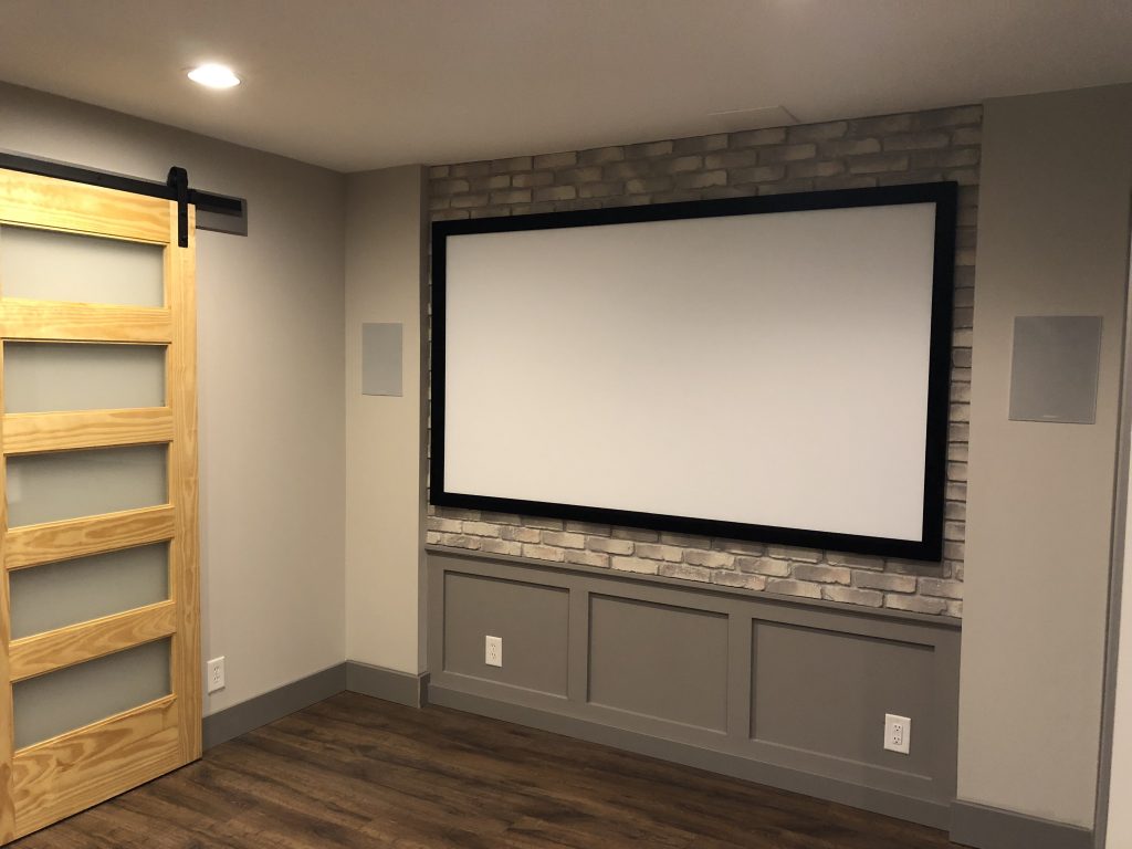 Whiteboard installed over a home office accent wall made with faux brick panels.