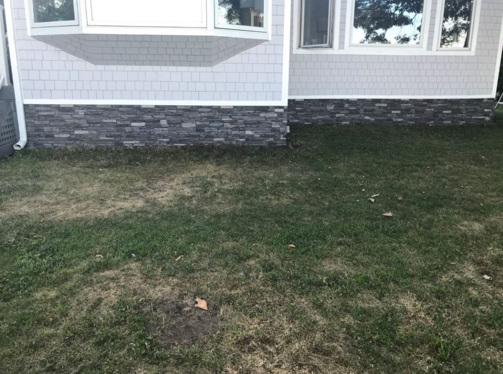 DIY mobile home remodel with stacked stone style panels installed as skirting.