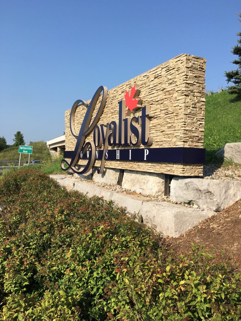 Welcome to town sign built for Loyalist township in Ontario, covered with stacked stone style panels.