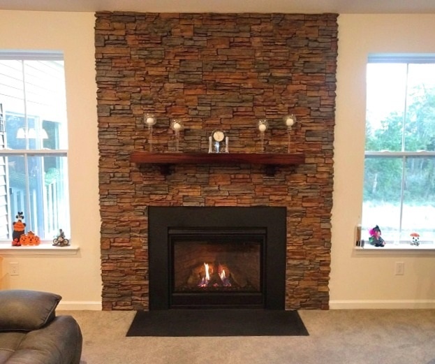 Fireplace wall design with stacked stone finish.