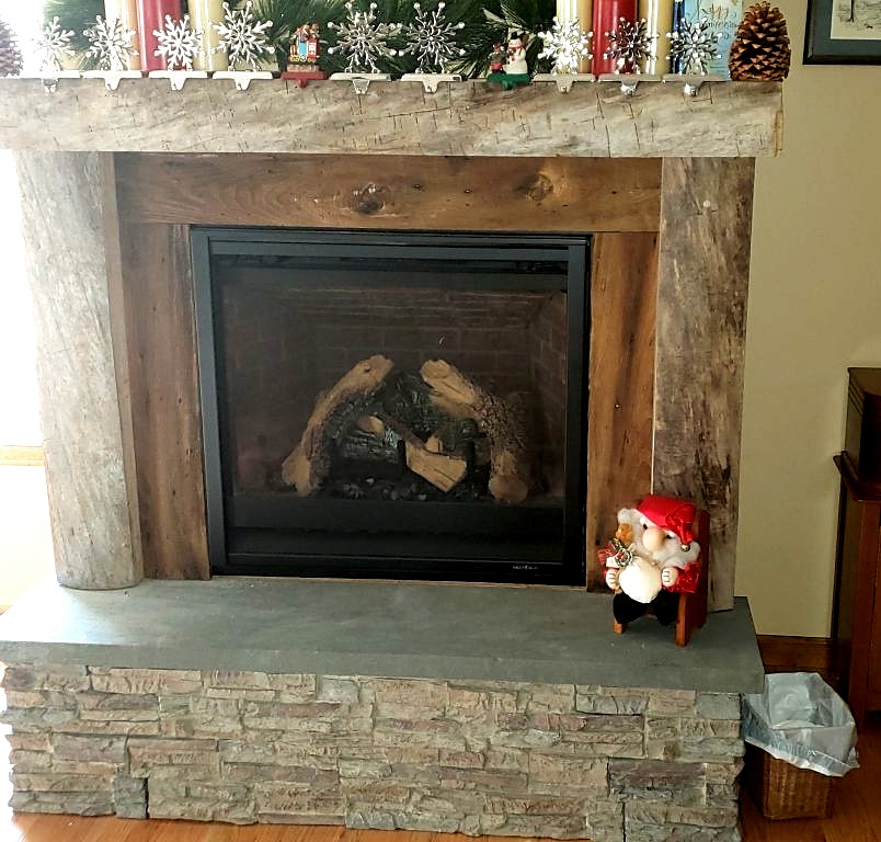 Fireplace constructed by a DIY'er using a combination of natural wood and faux stone materials.