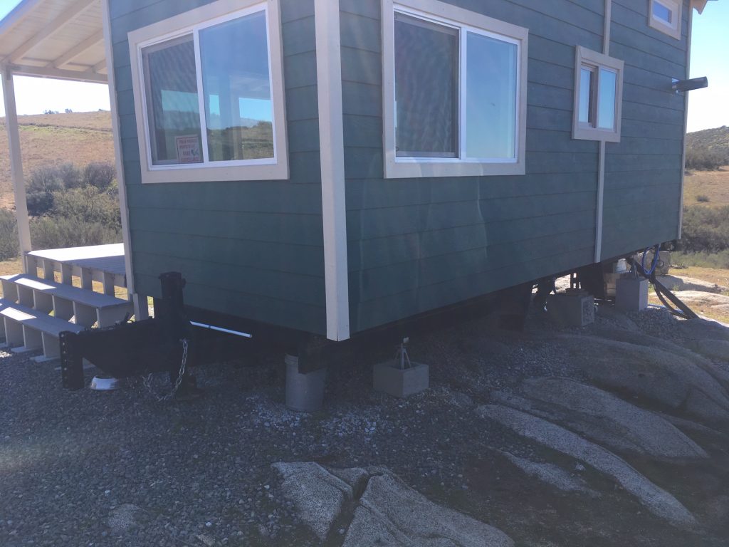 Before photo of prefabricated tiny house elevated with cinder blocks.