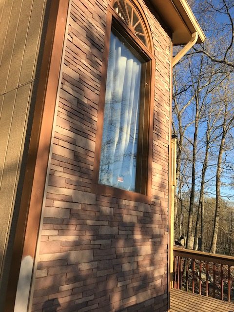 Stone Wall siding installed around a home's window frame.