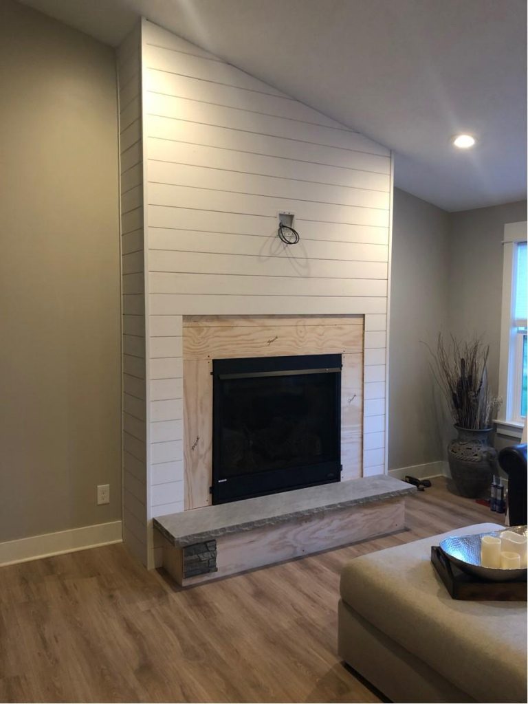Before image of fireplace project with a shiplap wall and stone panels Before image of fireplace project with a shiplap wall and stone panels