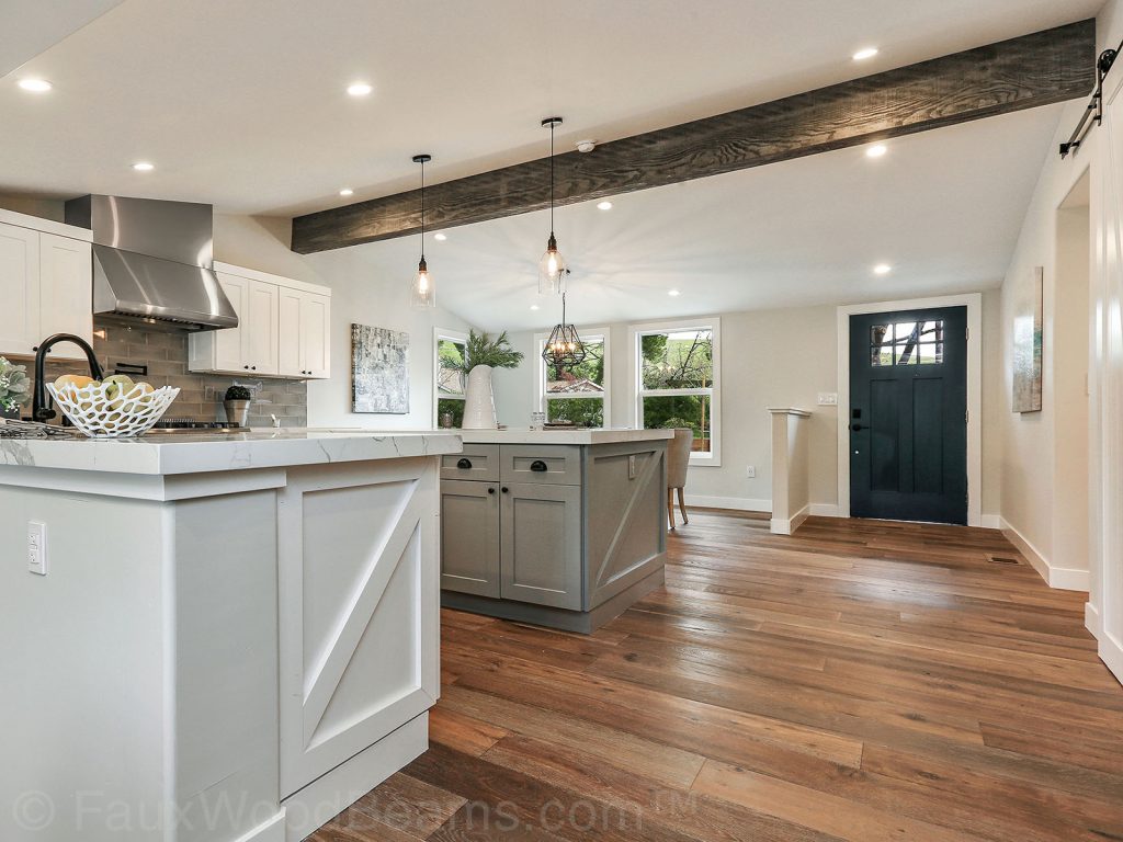 Kitchen with a single exposed ceiling beam and other rustic style details.