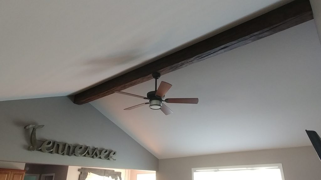 Ceiling beam on apex ceiling of family room with fan attached.